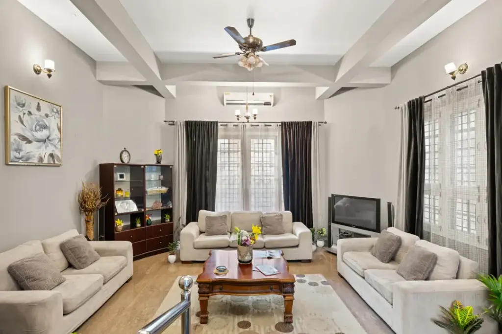 Spacious modern lounge at Natures Novelle with floor-to-ceiling glass windows and natural wood finishes for a cozy indoor-outdoor feel