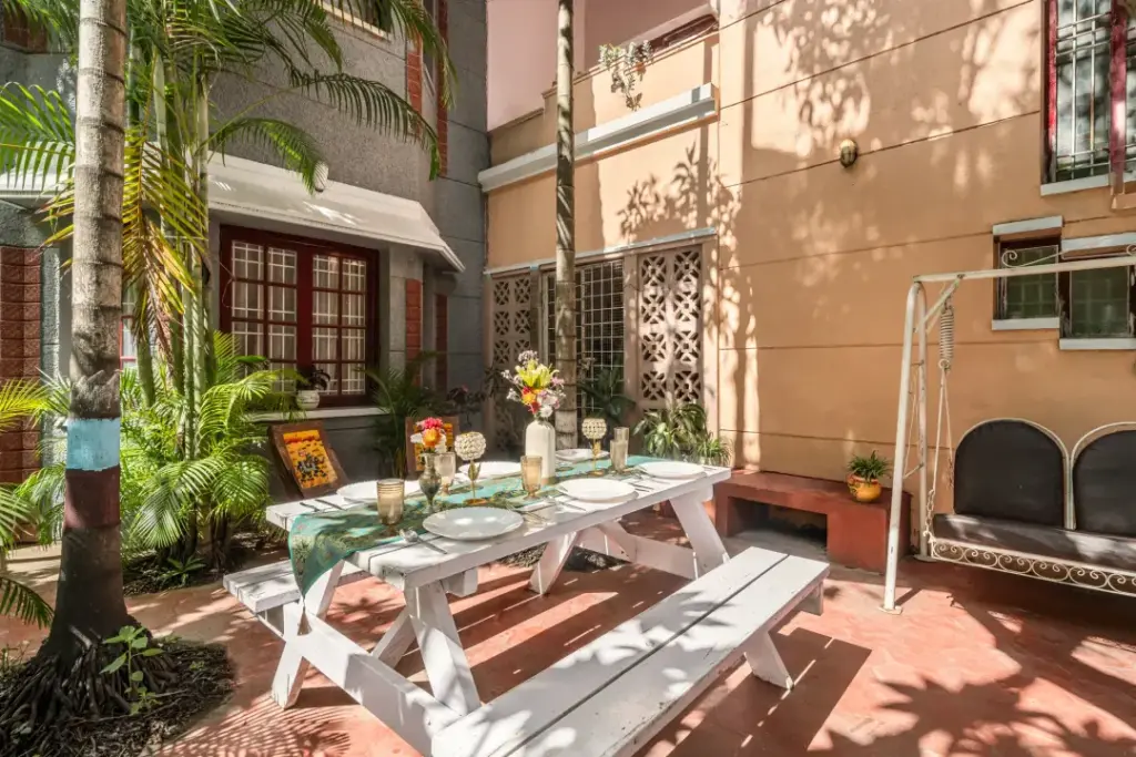 A secluded outdoor garden at Heritage Haven, surrounded by old-growth trees and lush plants, offering a private green sanctuary in the heart of the city.