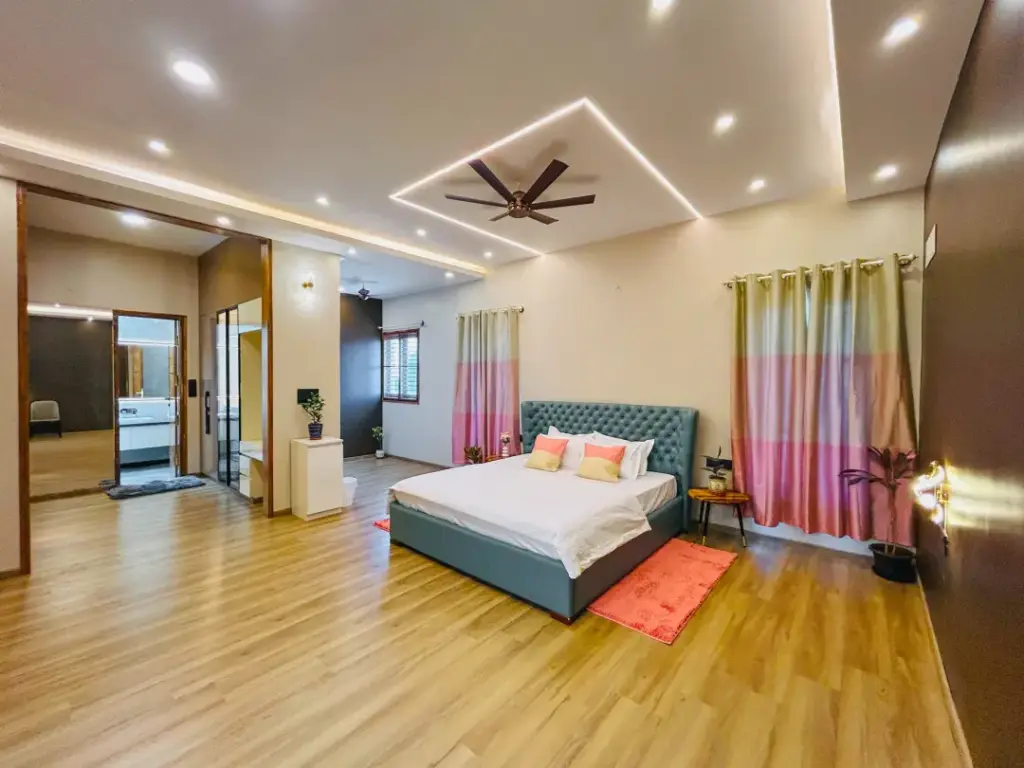 Spacious modern master bedroom at Aurora Heights with premium wooden flooring, contemporary decor, and large window views