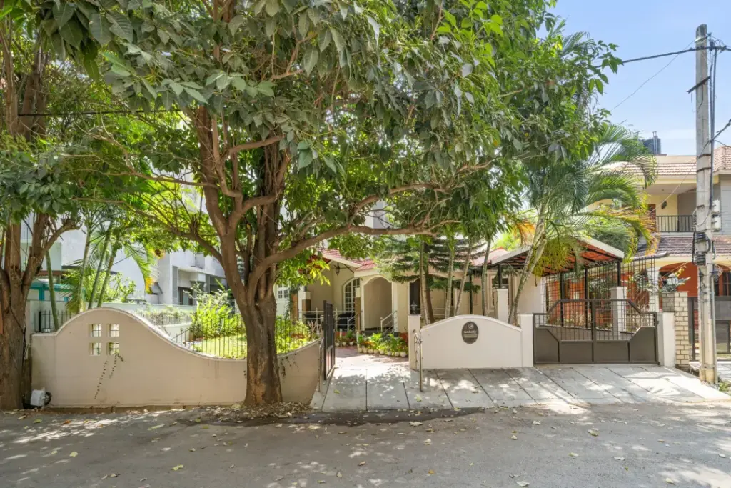 Contemporary white exterior of Natures Novelle by Spacez surrounded by sprawling green lawns and avocado trees in Sarjapur Bengaluru