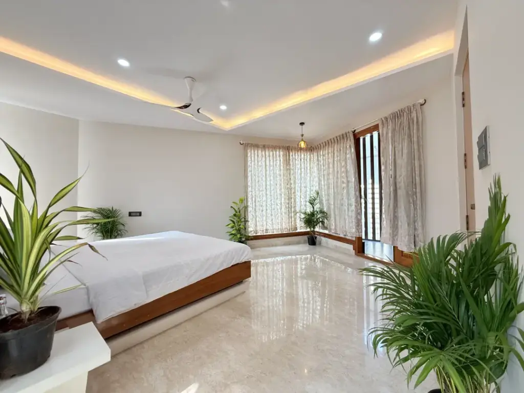 Master bedroom interior of a luxury Bengaluru villa featuring premium king-size bedding, warm ambient lighting, and minimalist modern decor for a peaceful retreat.