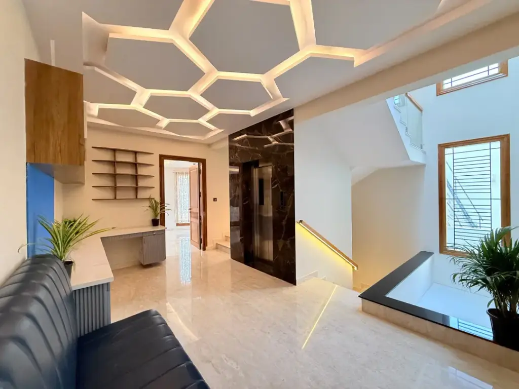 Elegant villa bedroom at Spacez with large glass windows offering a direct view of the private garden and allowing natural morning sunlight to fill the space.