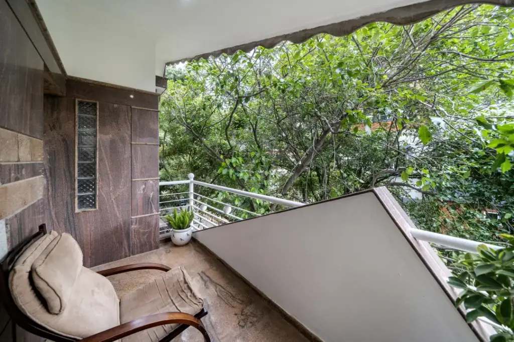 Spacious open balcony at Mansion Bay offering serene greenery views and comfortable seating for relaxation above HSR Layout Bengaluru