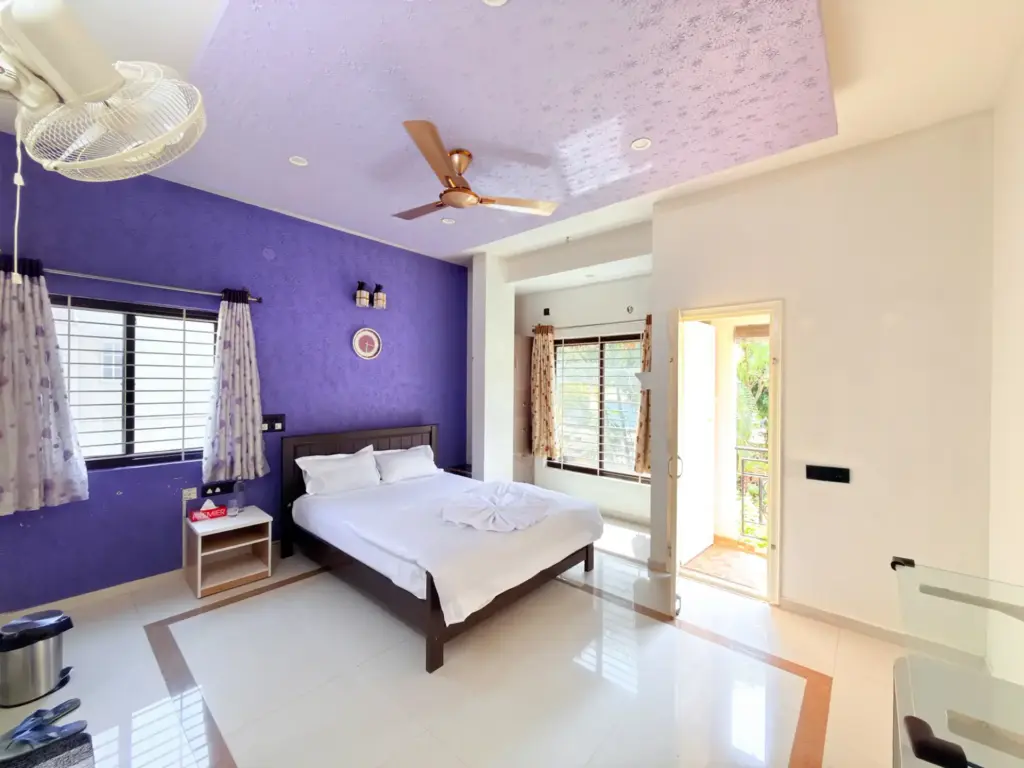 Serene Springs luxury bedroom interior with a minimalist aesthetic, high-quality wooden flooring, and floor-to-ceiling glass windows offering a tranquil view of the private garden.