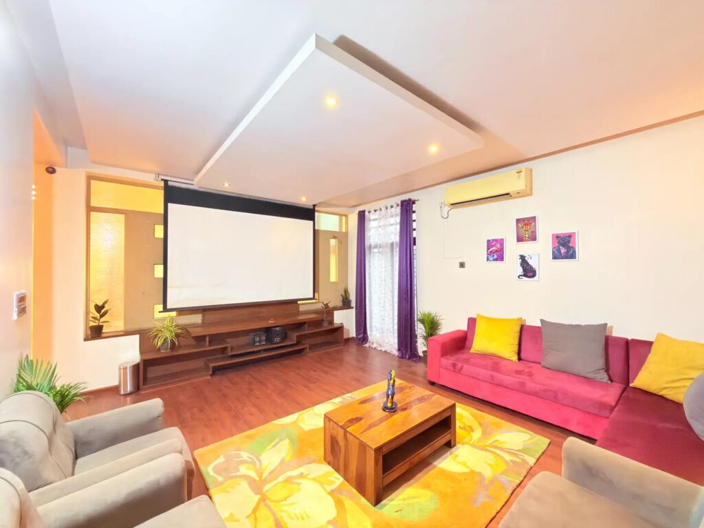 Private home cinema room featuring a large projector screen and premium seating.